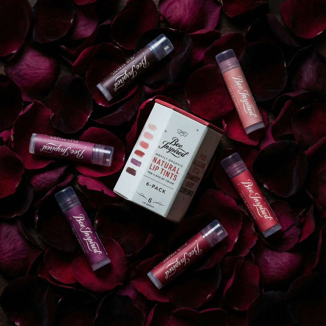 Set of lip tint tubes and packaging on red rose petals