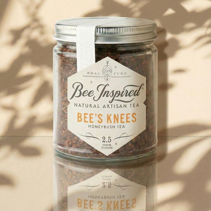 Jar of Bee's Knees Honeybush Tea with 'Bee Inspired' label on a reflective surface.