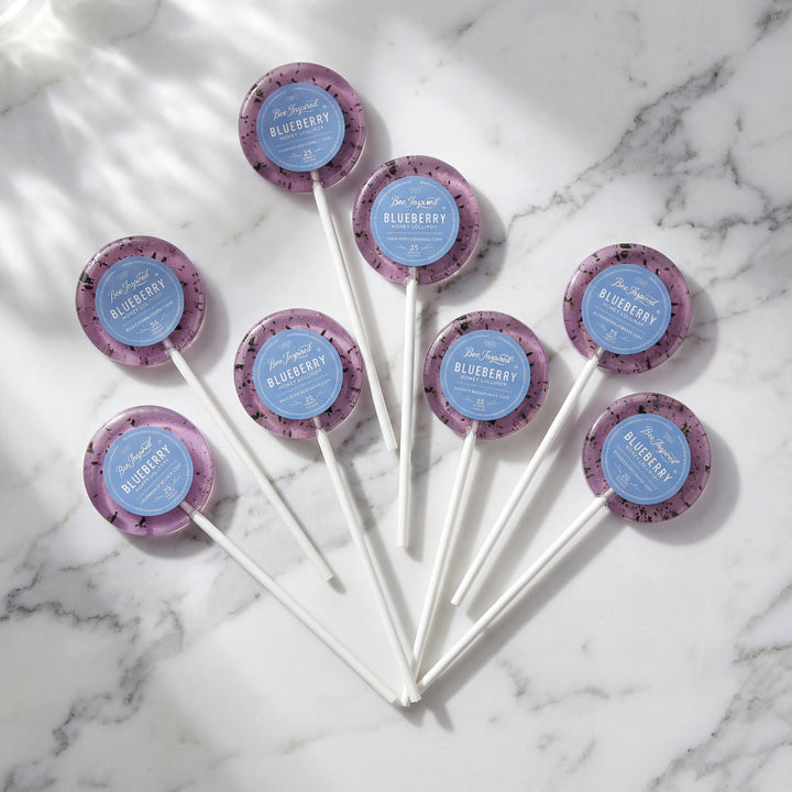 Blueberry-flavored lollipops on a marble surface