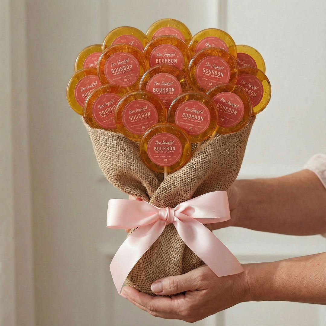 Bouquet of bourbon-themed lollipops with a pink ribbon held by a person.