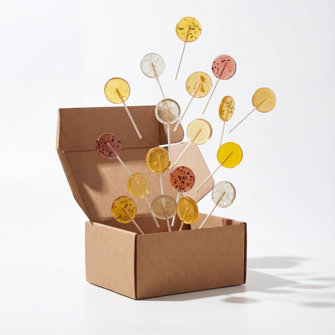 Decorative items on sticks in an open cardboard box against a white background