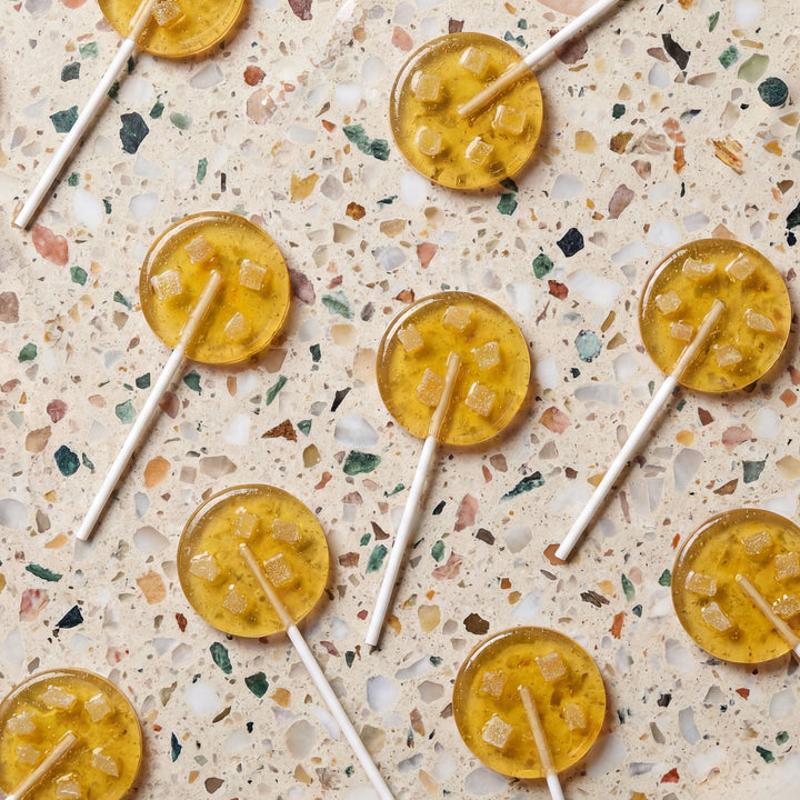 Yellow lollipops with sticks on a terrazzo countertop