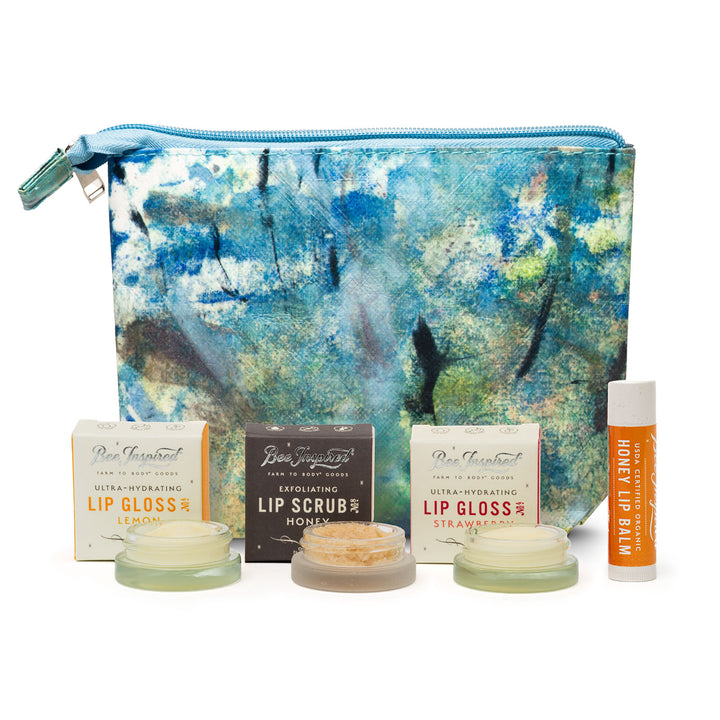 Set of lip care products including lip gloss, scrub, and balm with a decorative pouch on a white background.