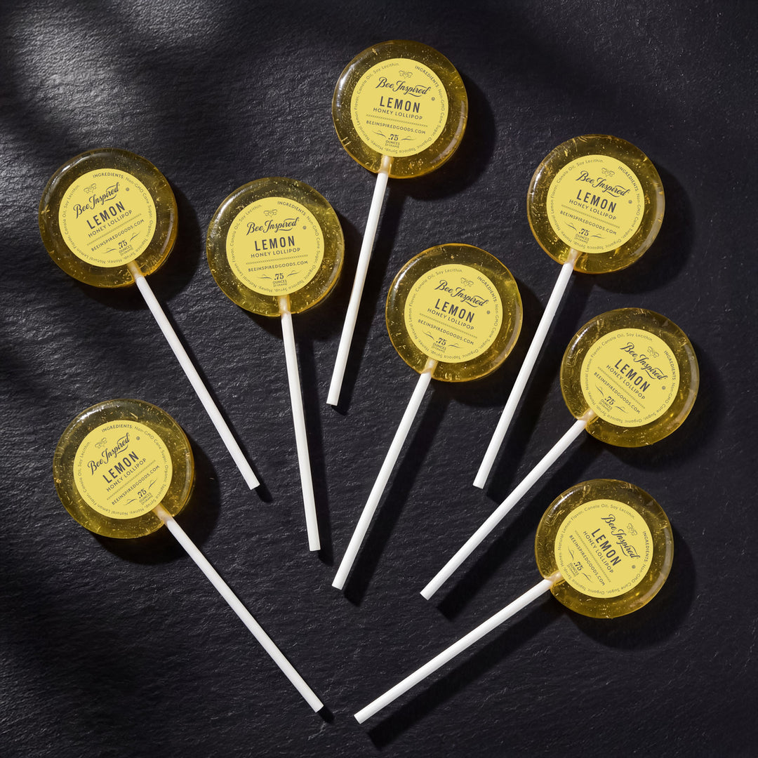 Lemon-flavored lollipops on sticks with yellow labels on a dark surface