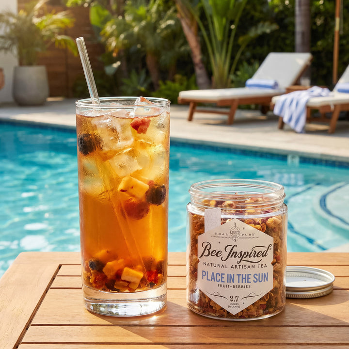 Glass of iced tea with a jar of 'Bee Inspired' tea by a poolside