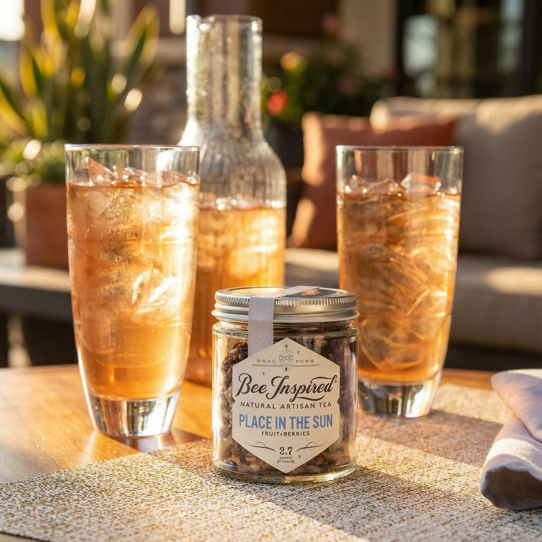 Two glasses of iced tea with a jar of 'Bee Inspired' tea on a table.