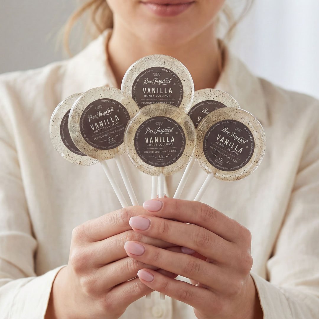 Person holding five vanilla product samples on sticks with visible branding.