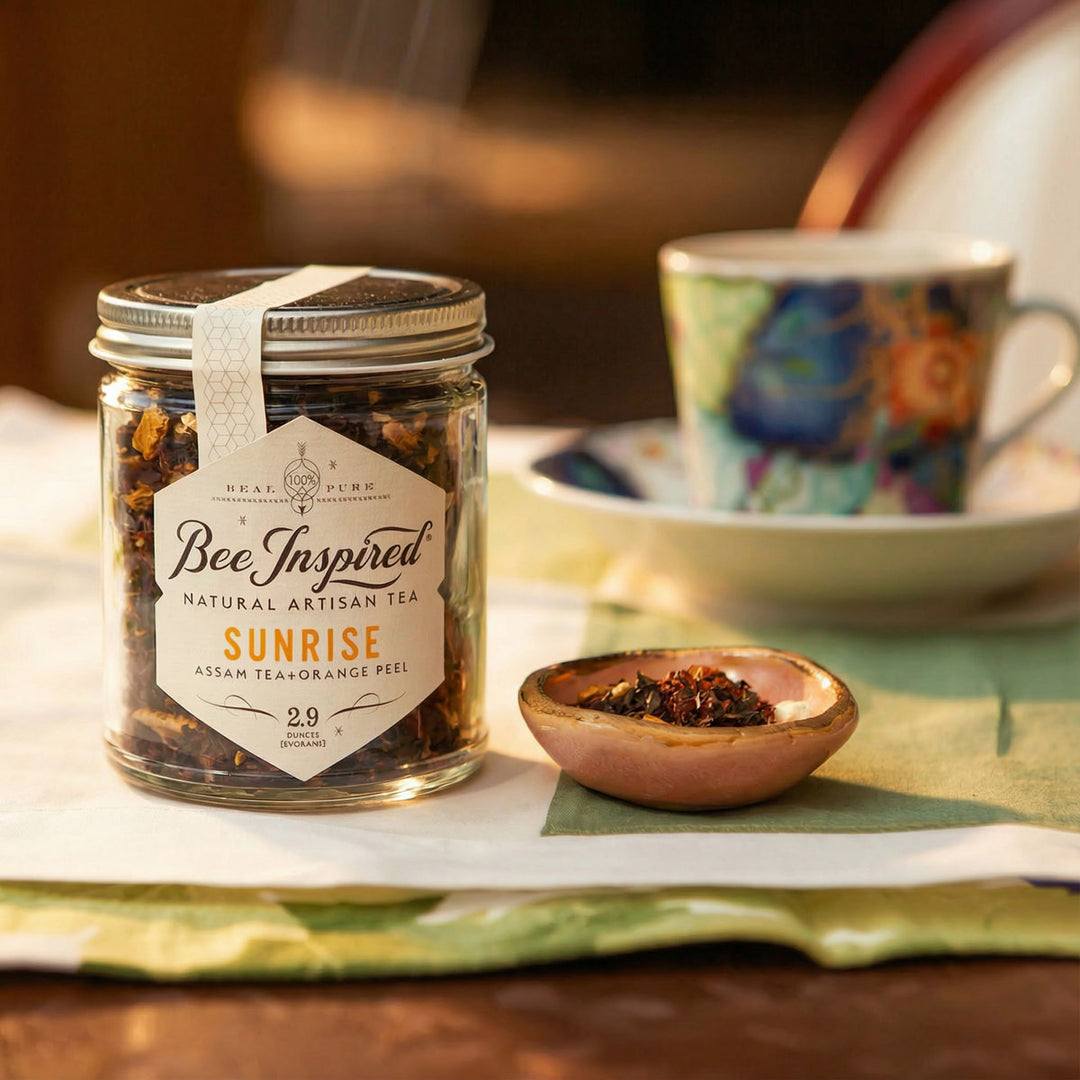 Jar of 'Bee Inspired' Sunrise tea with a cup and saucer in the background